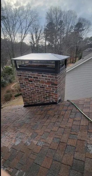 Same Atlanta chimney after masonry repair with a large cap over the flues