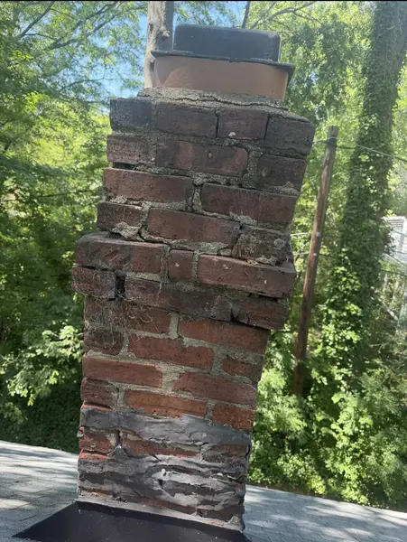 Severely deteriorated brick chimney with displaced masonry and open mortar joints
