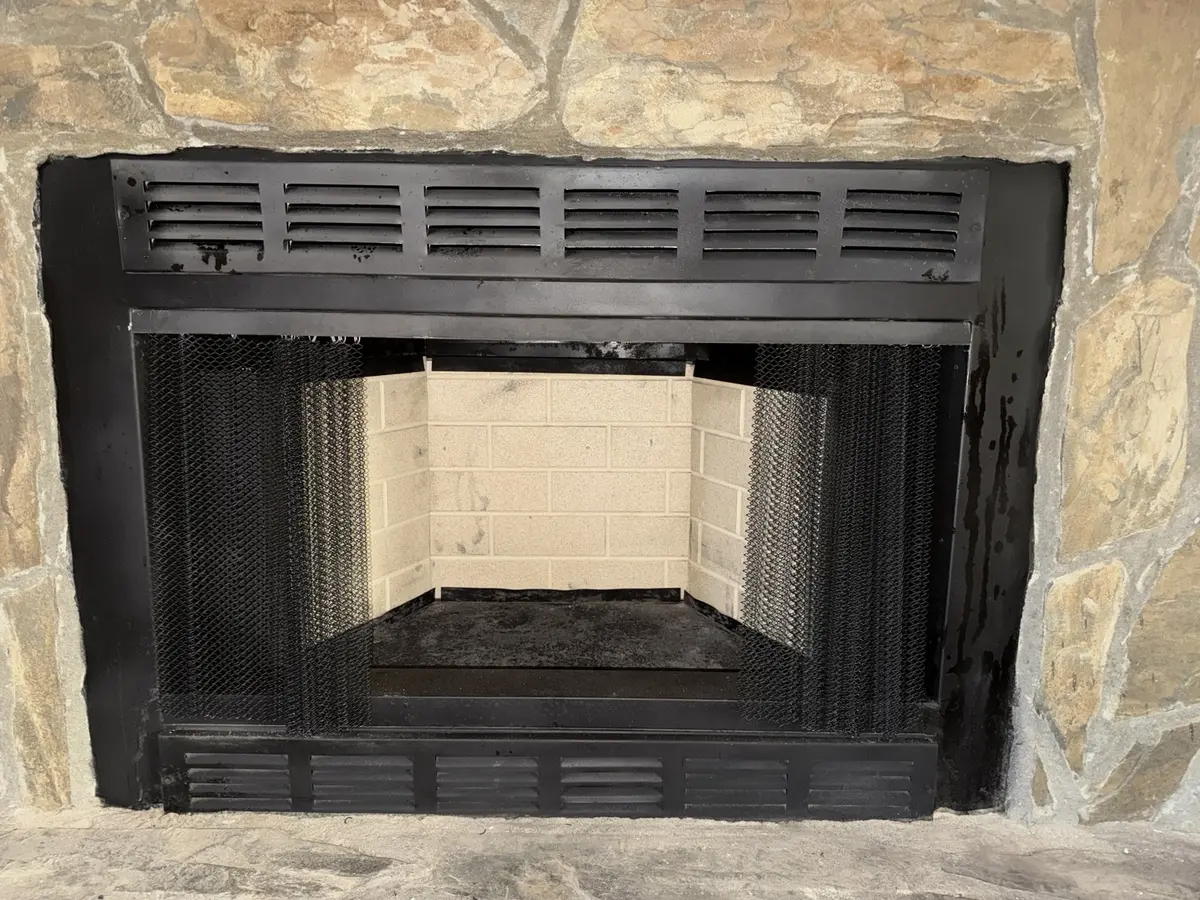 Fireplace firebox after masonry restoration with clean light-colored firebrick