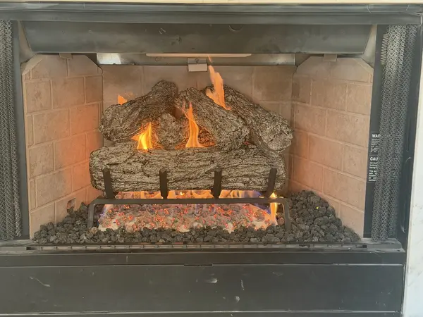 Gas log fireplace operating with a steady flame after service