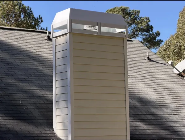 Same Marietta chimney chase after replacement, with new siding, trim and a white cover assembly