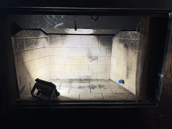 Roswell fireplace before gas-system installation, with an empty firebox and gas connection
