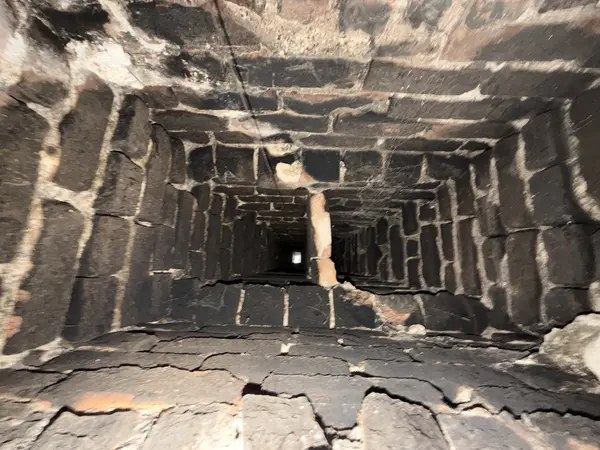 Smoke chamber interior before resurfacing, showing dark and irregular masonry surfaces